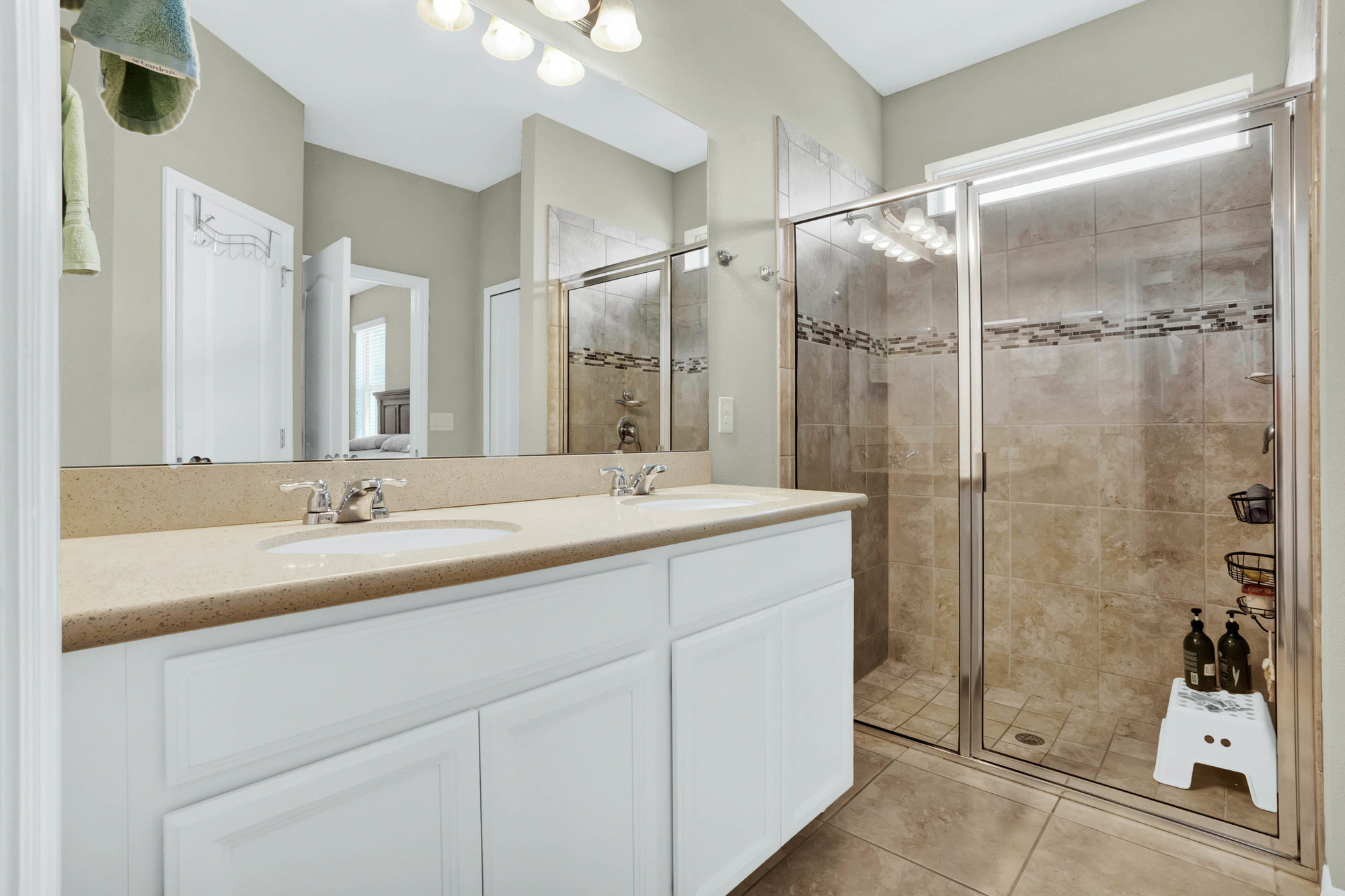 master bathroom with dual sinks and walk in shower
